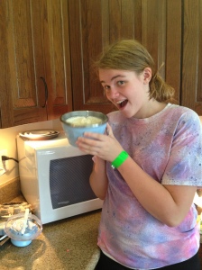 Alicia is excited about holding the freezing cold bowl of ice cream. 